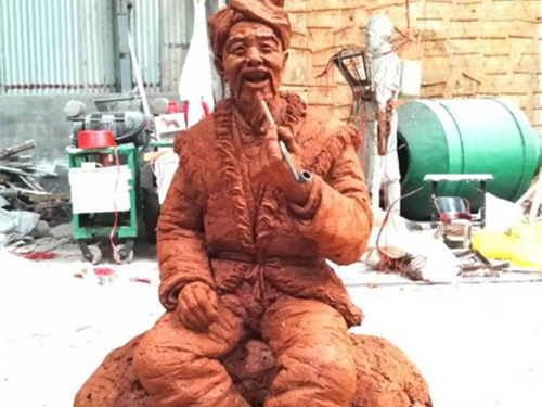 著(zhù)色后的抽旱煙西北農民泥塑模型